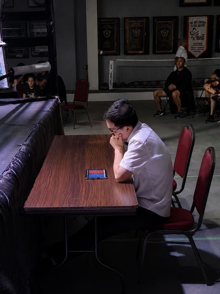 A boxing official using RingScore from a ringside position.